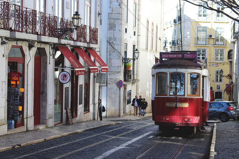 Ascenso de un tranvia rojo por una de las calles del barrio de Alfama, en Lisboa.