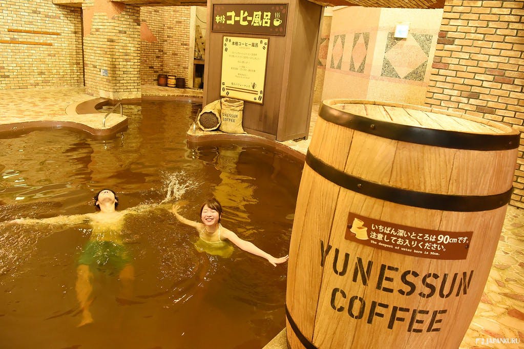 Dos personas bañándose en un onsen de café en Kowakien Yunessun