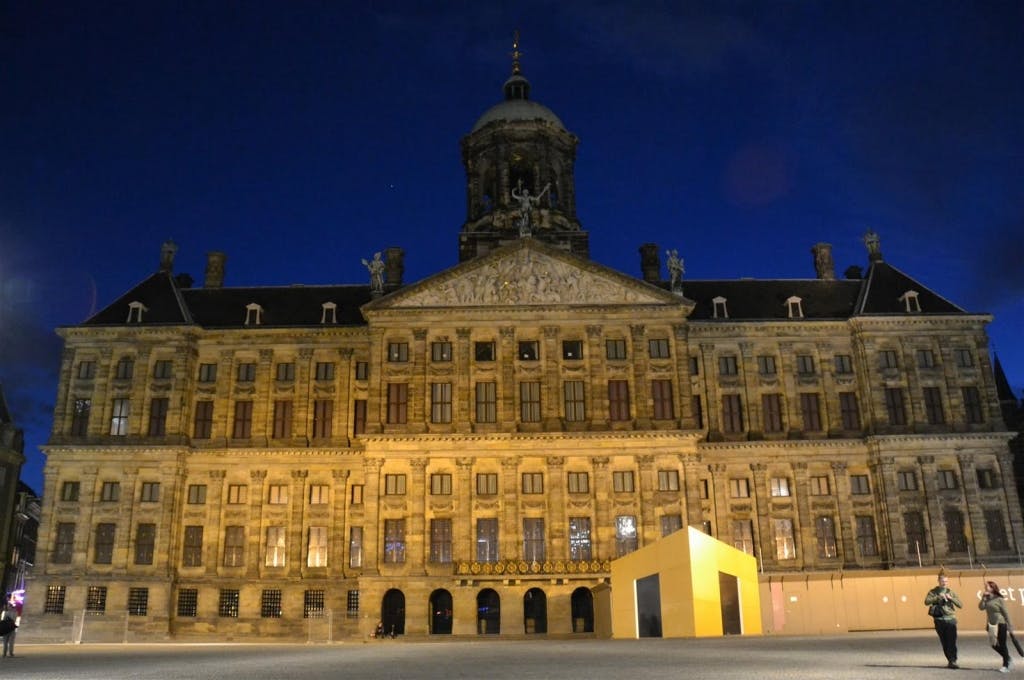 Palacio Real de Ámsterdam iluminado de noche.